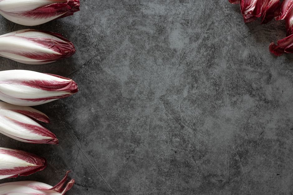 Endives rouges fraîches disposées sur une ardoise sombre
