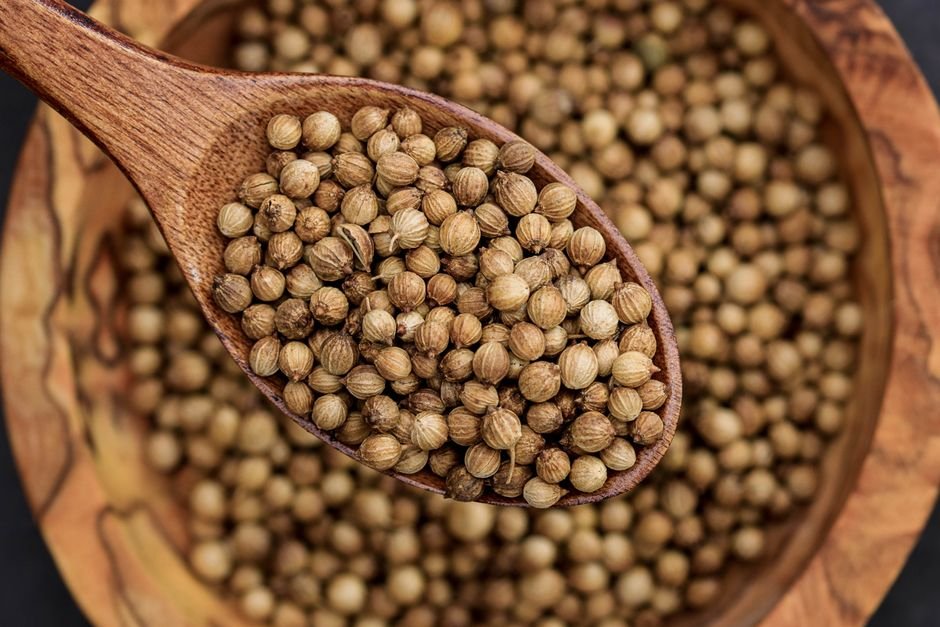 Graines de coriandre dans une cuillère en bois